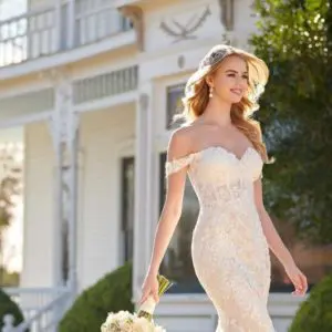 Slight fit and flare dress, off-the-shoulder and embellished pearl-beaded lace with 3-dimensional flowers. Sweetheart neckline extends to drapey, lace, removable off-the-shoulder straps.