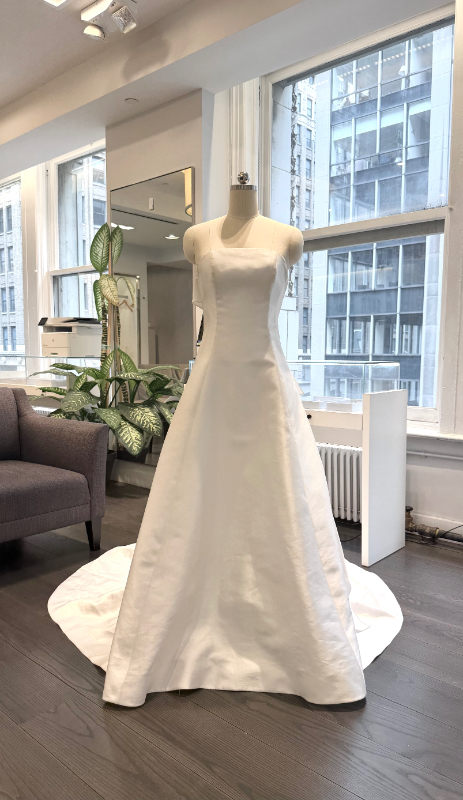 Allison Webb Baxley Wedding Dress - Snow mikado A-line gown with crescent neckline, and origami half bow, and chapel train. Optional pearl illusion halter.