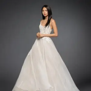 Lazaro Vanessa 3860 Wedding Dress - Silk organza A-line bridal gown, scalloped ballerina neckline with crisscross straps at open back, shear lace bodice over nude lining, circular A line organza skirt accented with lace appliqués.