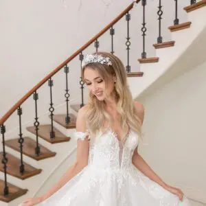 Estee Couture Nikita Wedding Dress - A Line style dress with glitter tulle, floral appliqués, sweetheart neckline, deep v plunging and off shoulder straps.