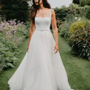 Suzanne Neville Hailey Wedding Dress - A Line featuring a square neckline in crepe, eloquent belt detail and organza skirt.
