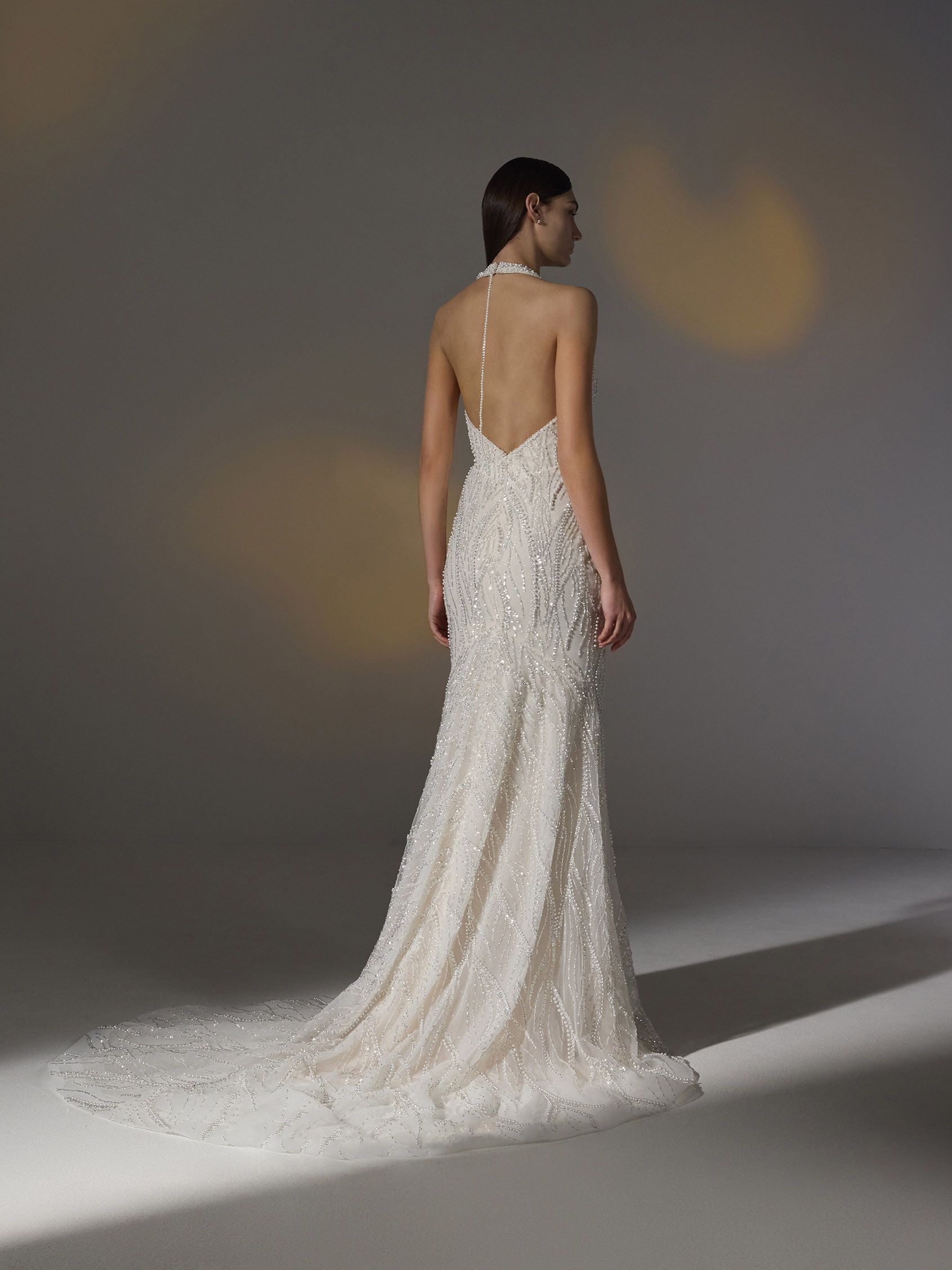 Pronovias Amorosa Wedding Dress - Fit and flare style dress with deep v-plunging neckline, front slit and lace with allover beads detail.
