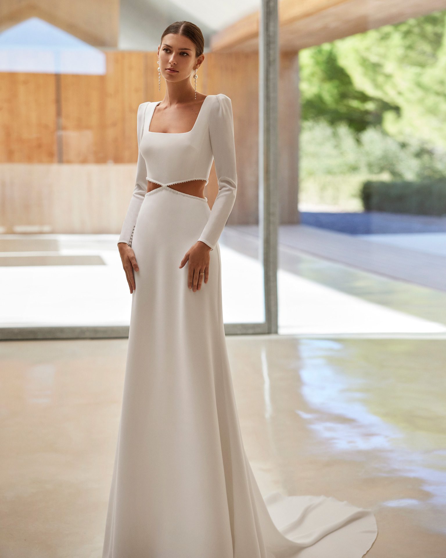Modern sheath-style wedding dress, crafted in stretch crêpe. Featuring a square neckline, closed back, long sleeves and a cut-out embellishment.