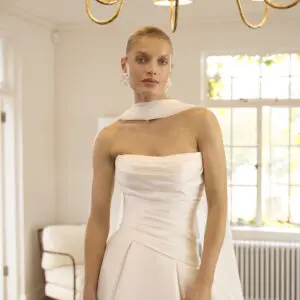 La Premiere Bernadette Wedding Dress - A-line style dress with asymmetrical waistline, draping bodice, box pleats in skirt, front slit in mikado fabric.