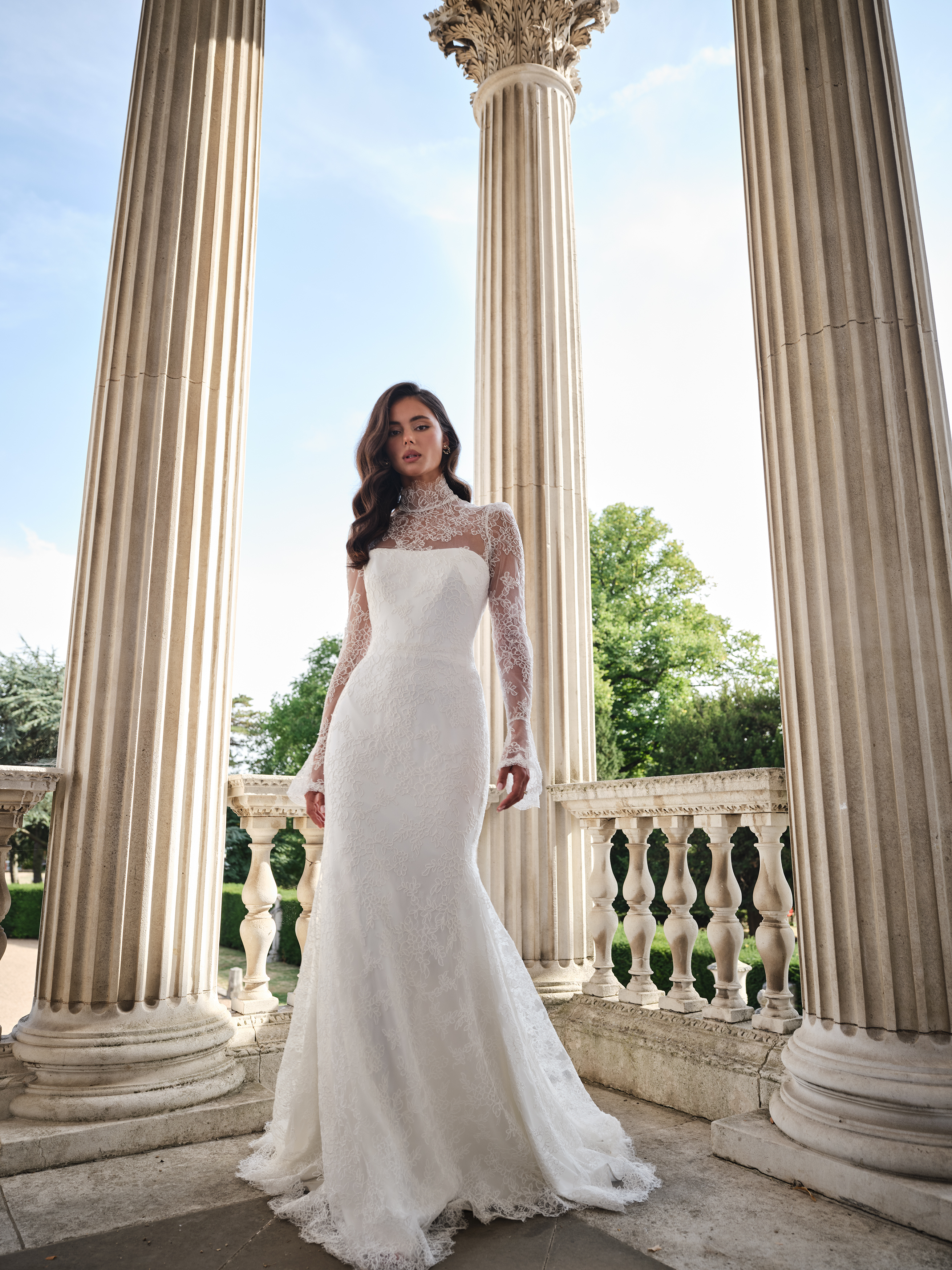 Suzanne Neville Aurora Wedding Dress - Romantic Modern Couture Fit and Flare Bridal Gown with Natural Waist, High Neck, Long Sleeves, Corset and Train Details and Lace Fabric