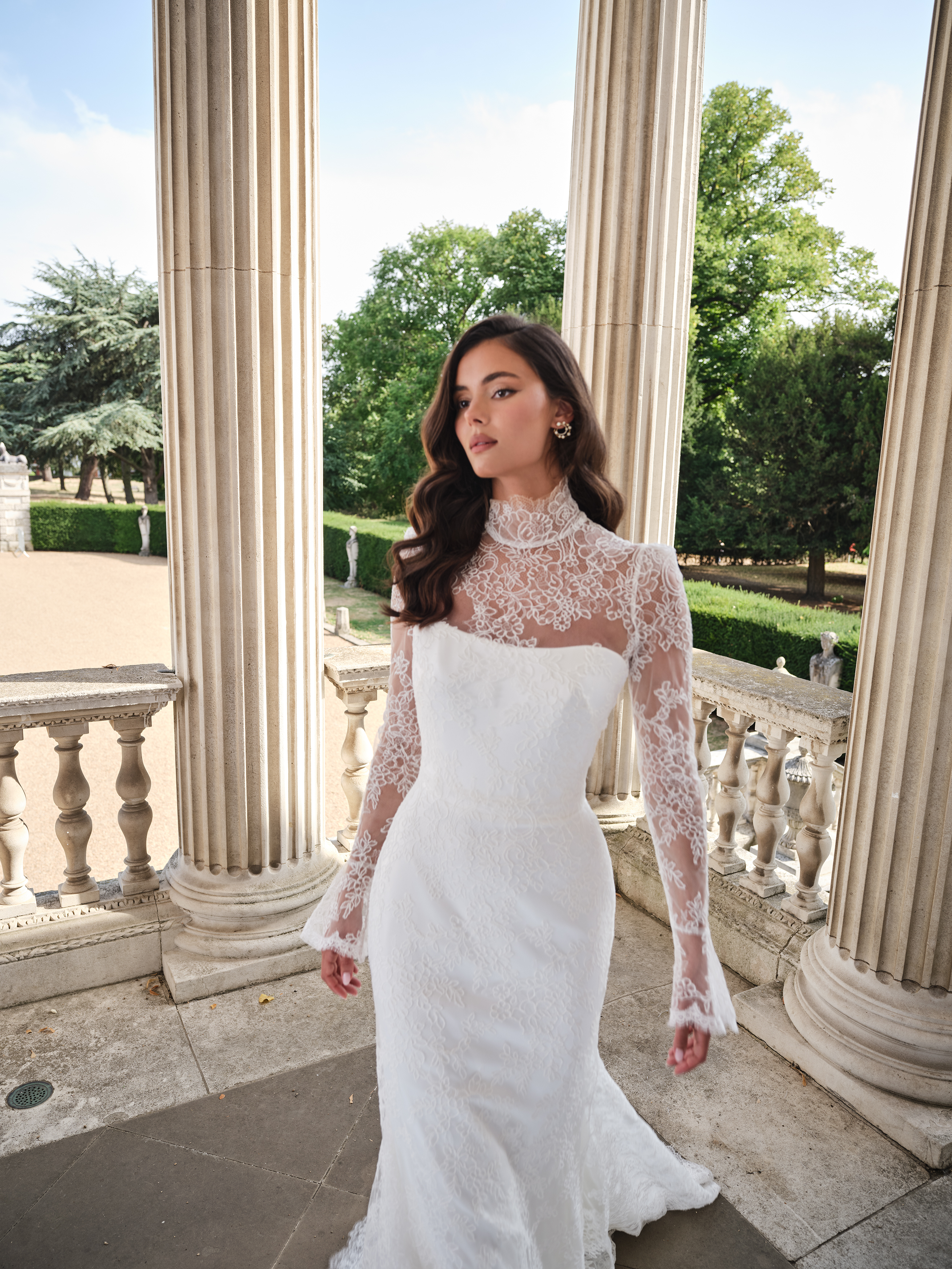 Suzanne Neville Aurora Wedding Dress - Romantic Modern Couture Fit and Flare Bridal Gown with Natural Waist, High Neck, Long Sleeves, Corset and Train Details and Lace Fabric