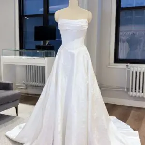 La Premiere Cyra Wedding Dress - Timeless Classic Modern Bridal Gown with Basque Waist, Strapless Cat-eye Neckline, Corset, Texture, Draping and Floral Details in Jacquard Fabric.